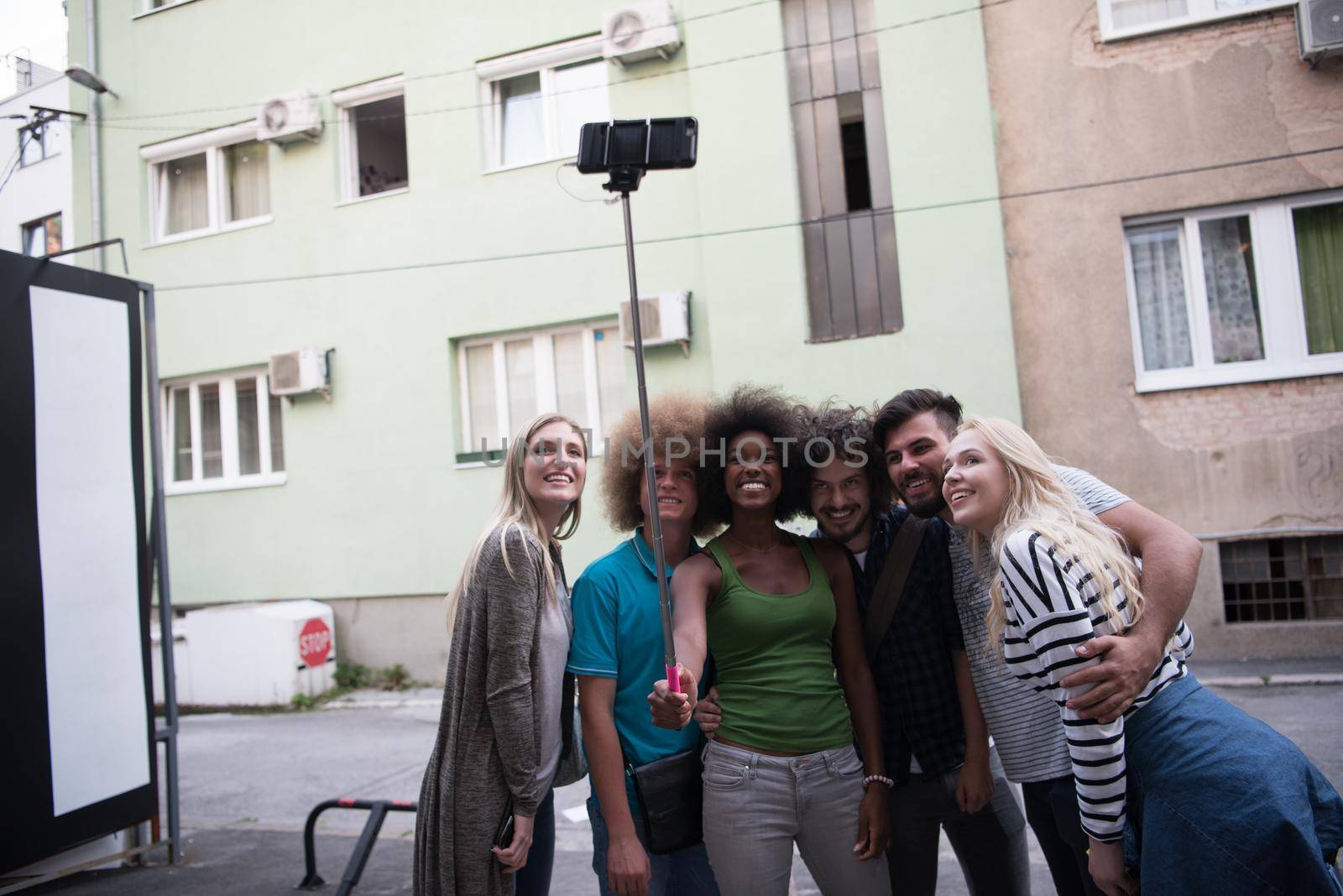 Multiethnic Group of friends taking picture of themselves with smartphone