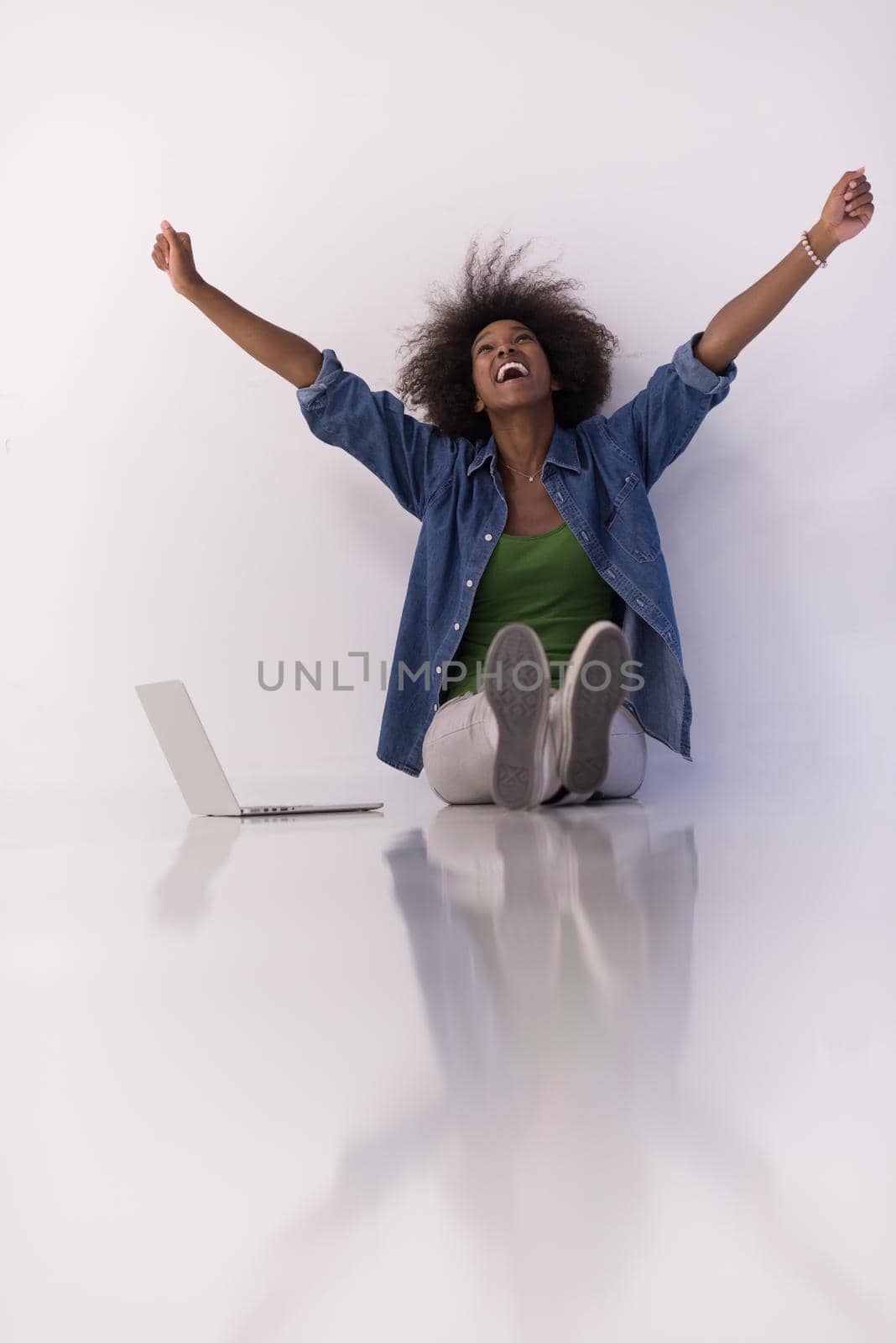 african american woman sitting on floor with laptop by dotshock