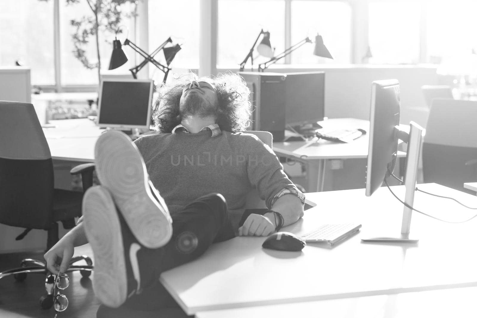 businessman sitting with legs on desk by dotshock