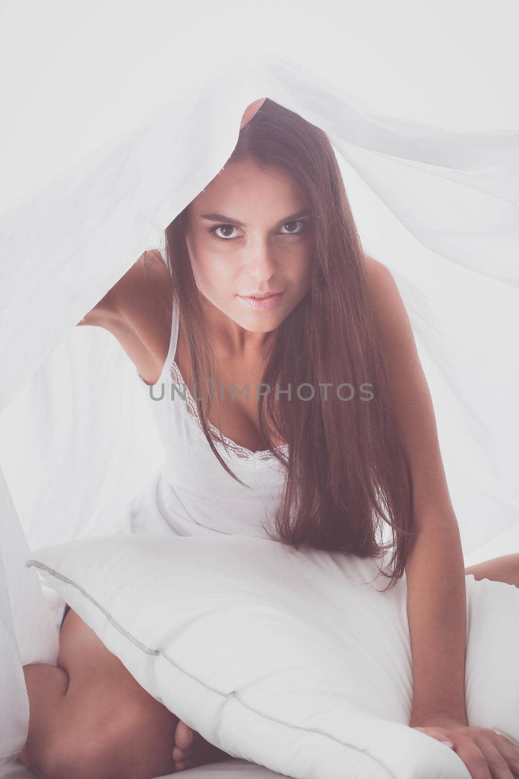 Young beautiful woman lying in bed under cover.