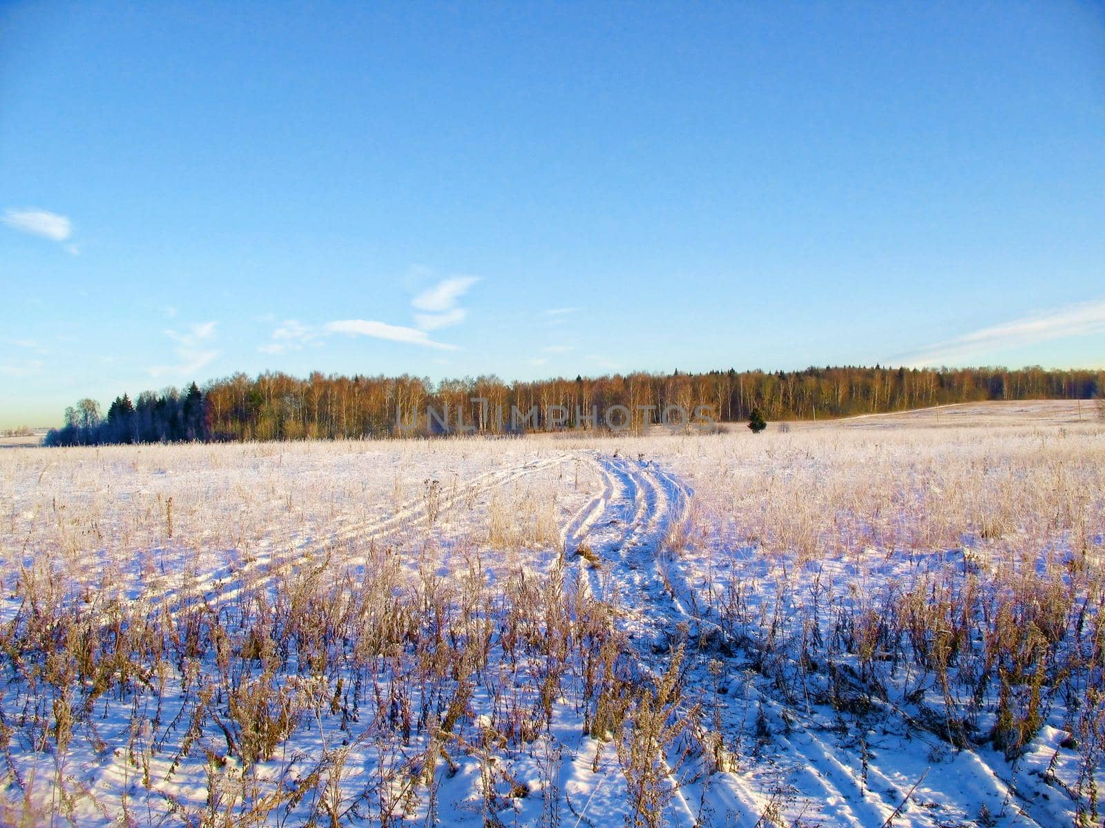 The snow-covered road is an early, sunny, frosty morning in the suburbs.