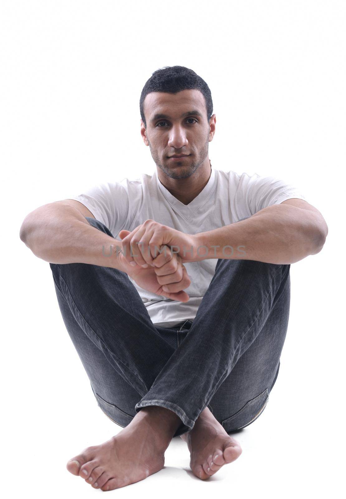 portrait of relaxed young man dressed in white shirt and jeans isolated over white background in studio