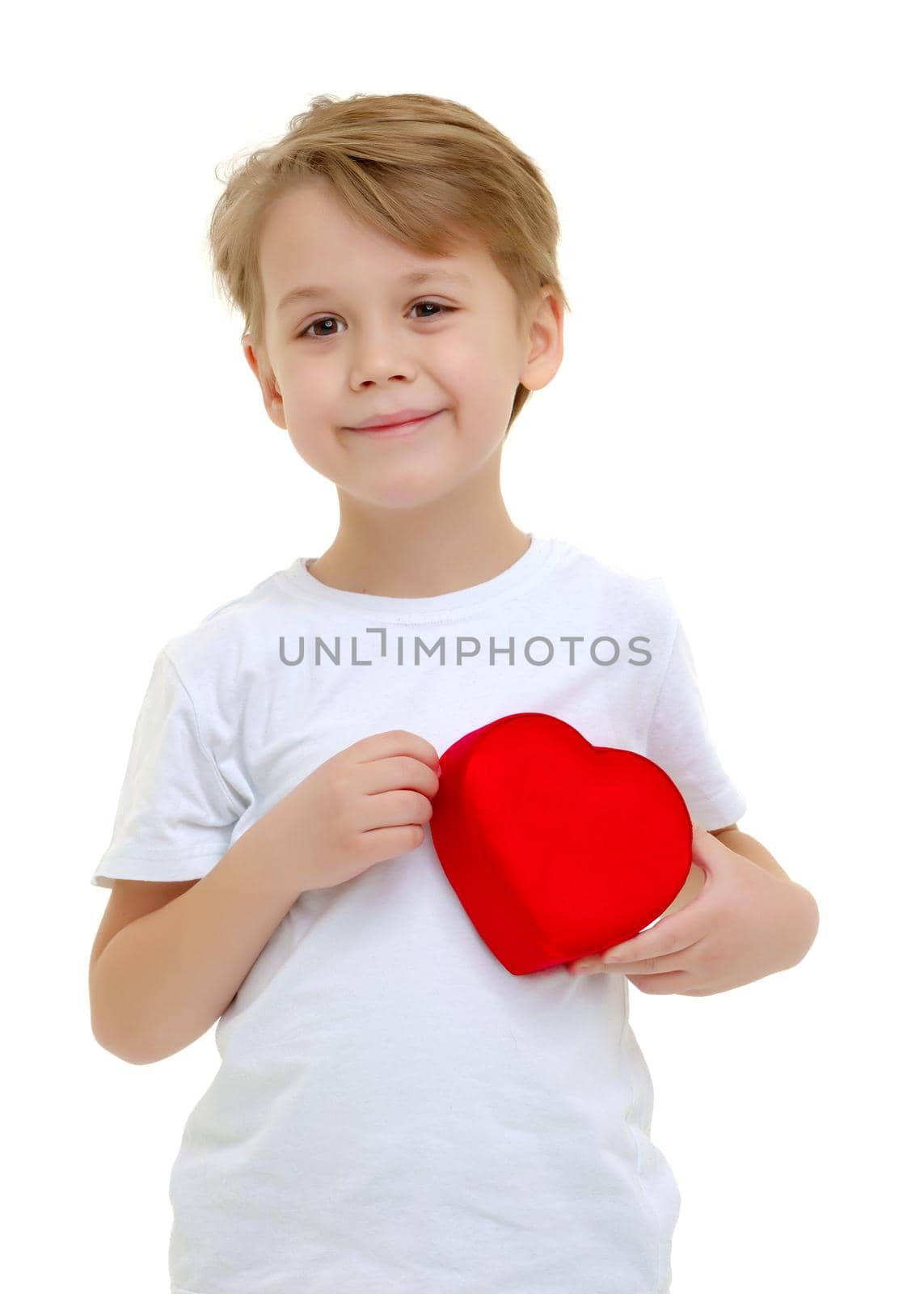 A little boy is smiling with a red heart figure. Symbol of love, family, hope. Background to the Valentine's day. Isolated on white background.