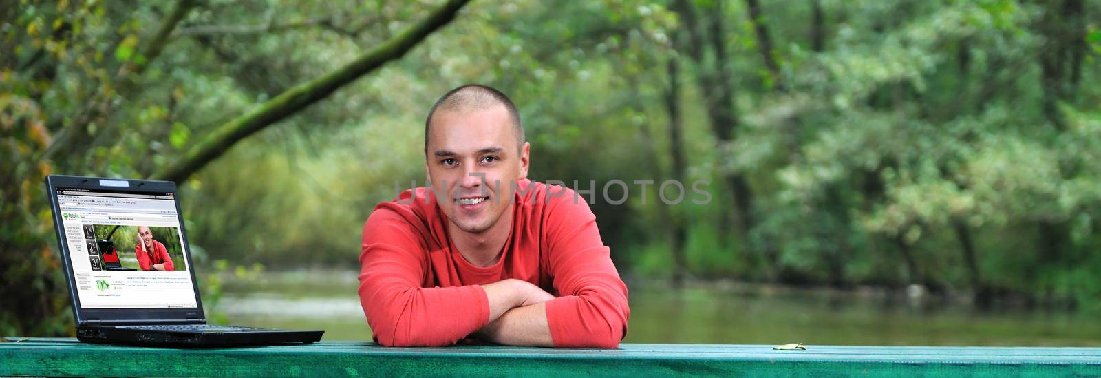 young businessman in red shirt working on laptop  by dotshock