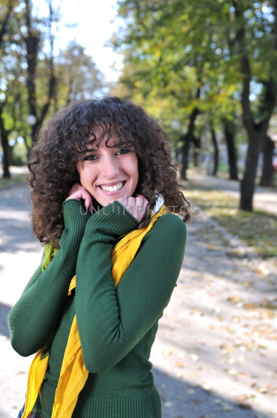 brunette Cute young woman with colorful scarf smiling outdoors in nature
