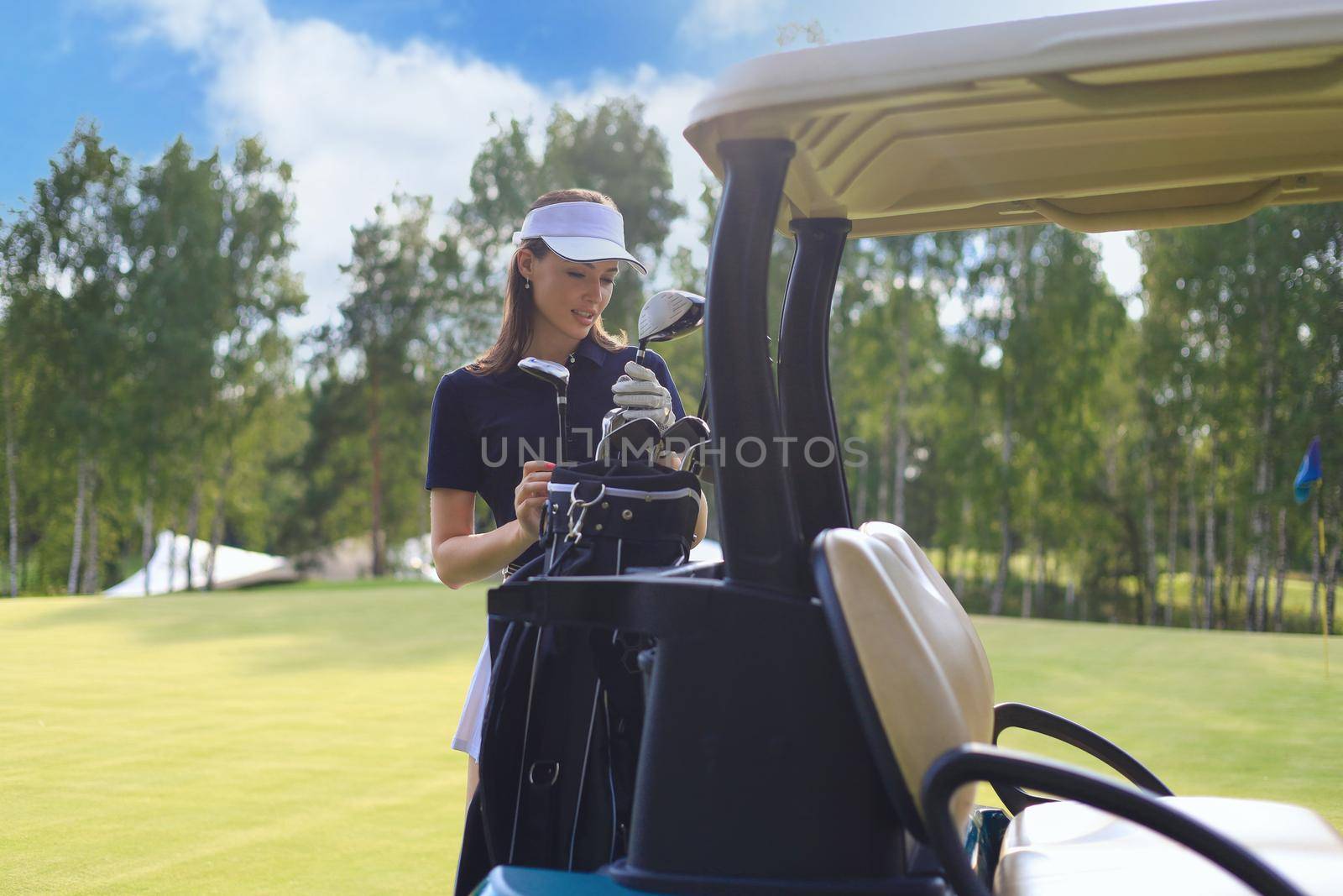 Beautiful cheerful woman standing near in golf cart