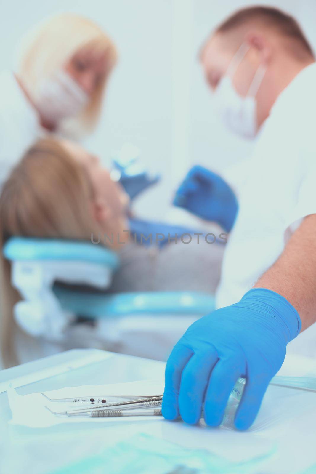 Detail of hand holding dental tools in dental clinic. Dentist Concept by lenets