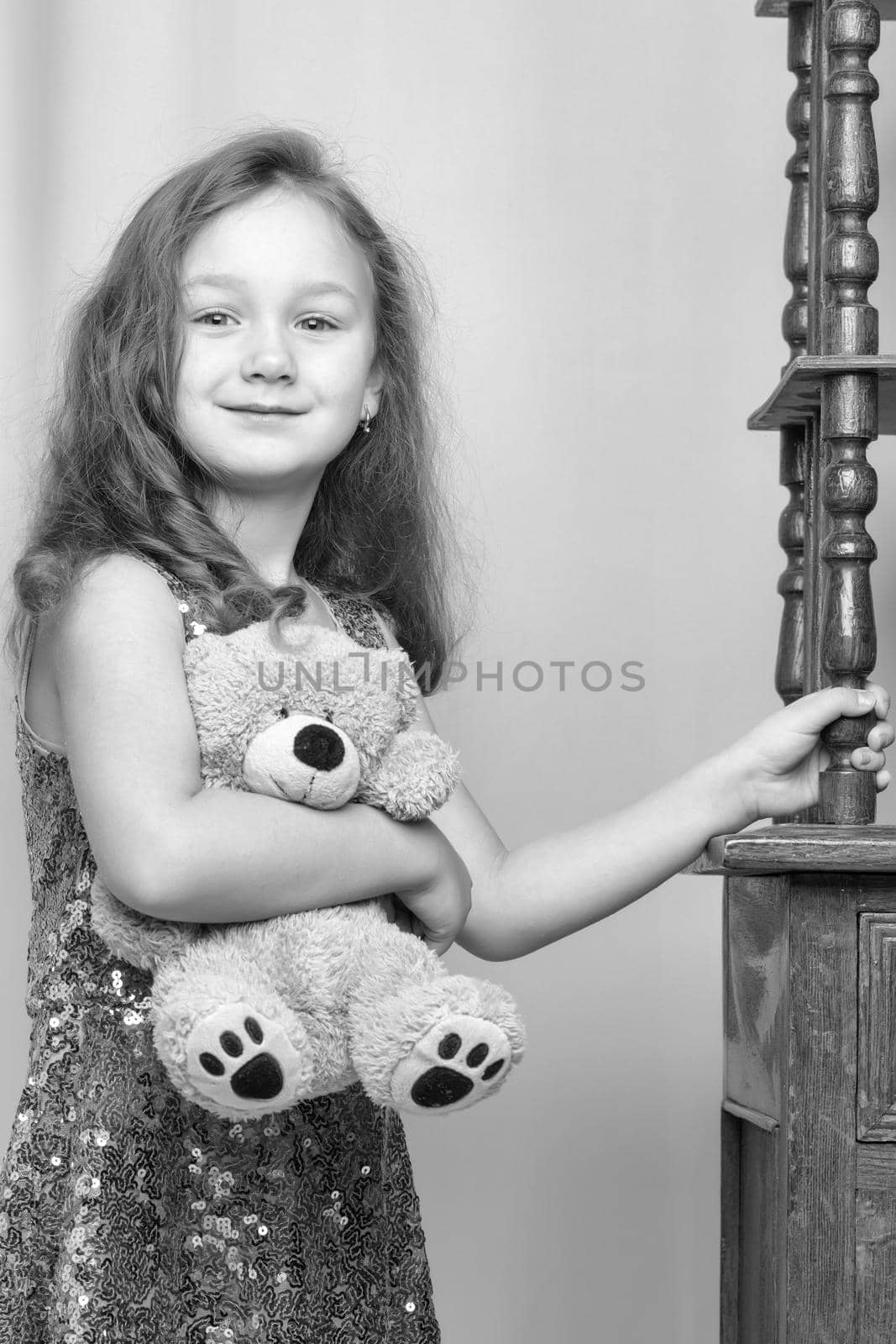 Little girl near the beautiful old bedside table. Photo in vintage style.