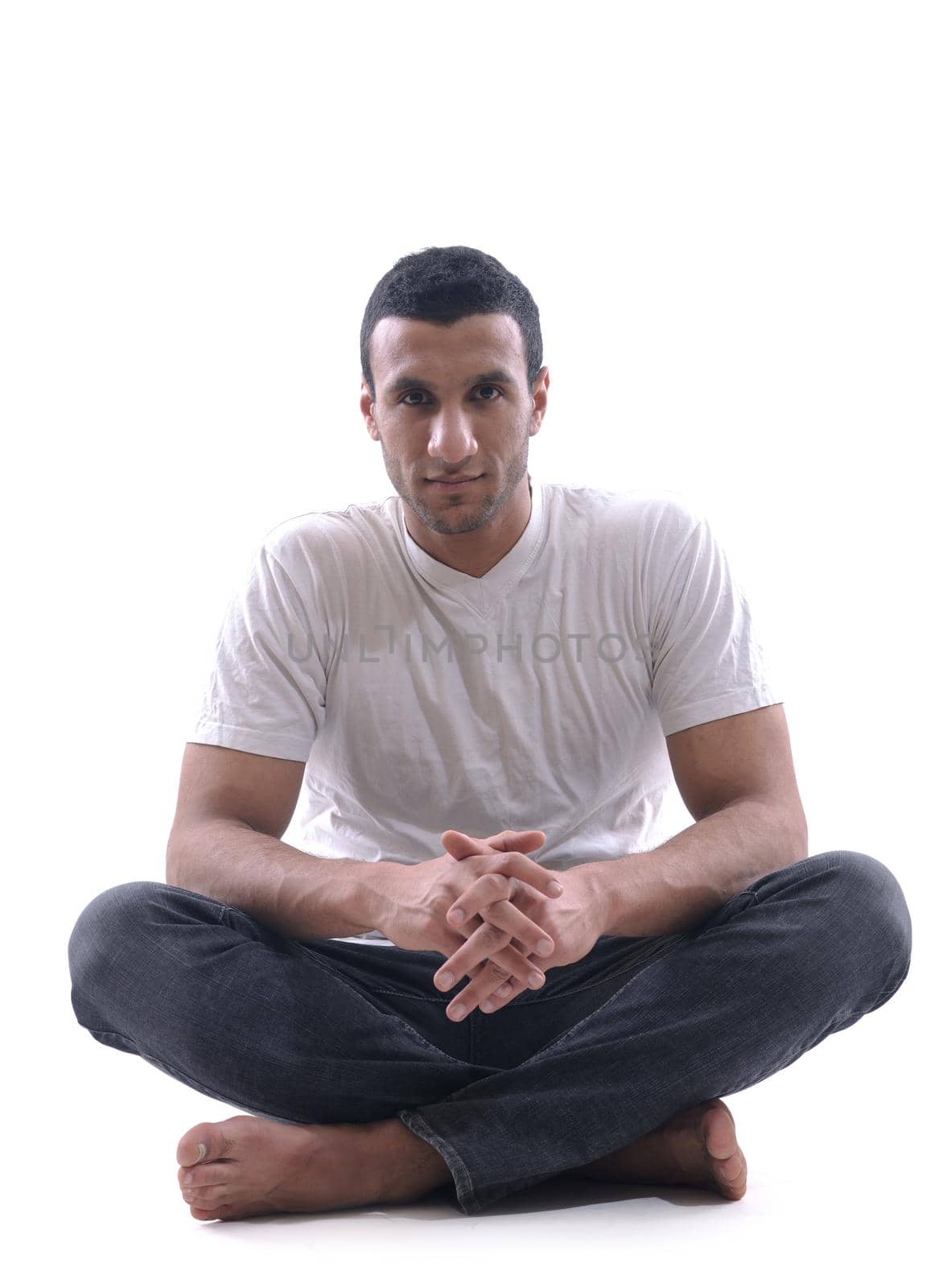 portrait of relaxed young man dressed in white shirt and jeans isolated over white background in studio