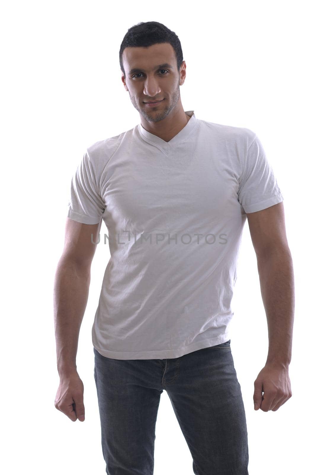 portrait of relaxed young man dressed in white shirt and jeans isolated over white background in studio