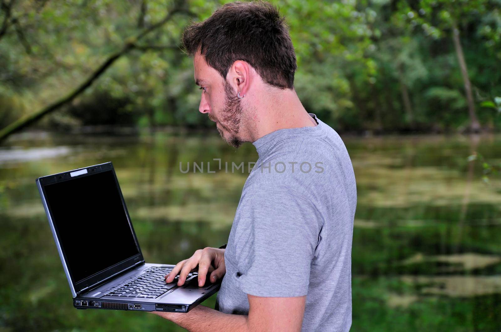 young businessman working on laptop outdoor by dotshock