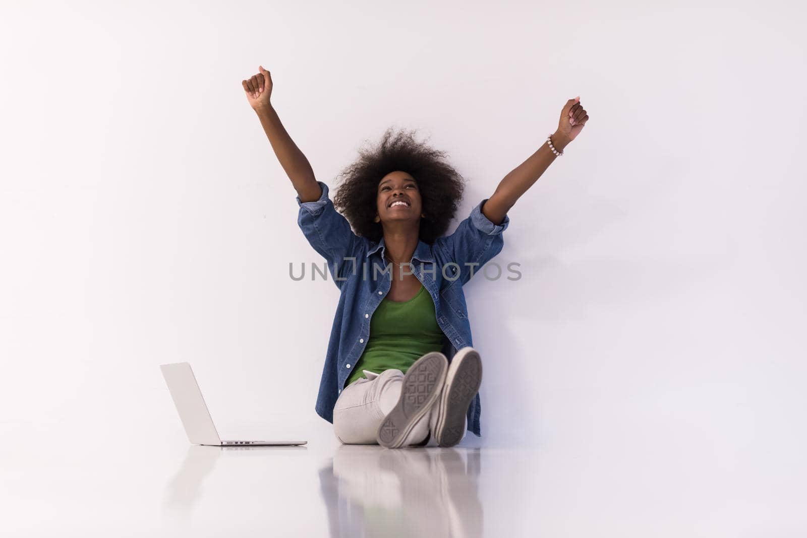 african american woman sitting on floor with laptop by dotshock