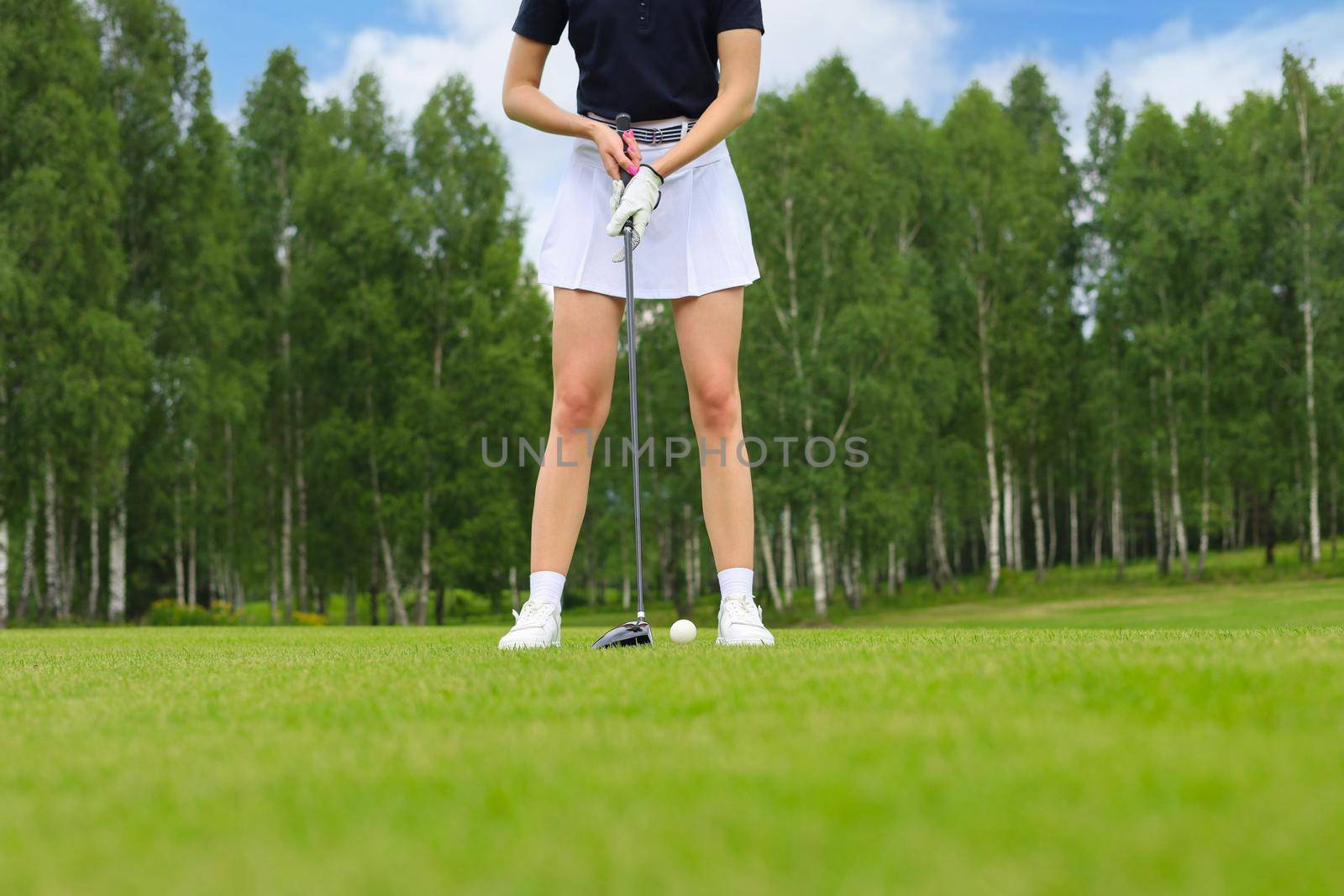 Beautiful woman golfer prepare to shot on ball on the green golf course