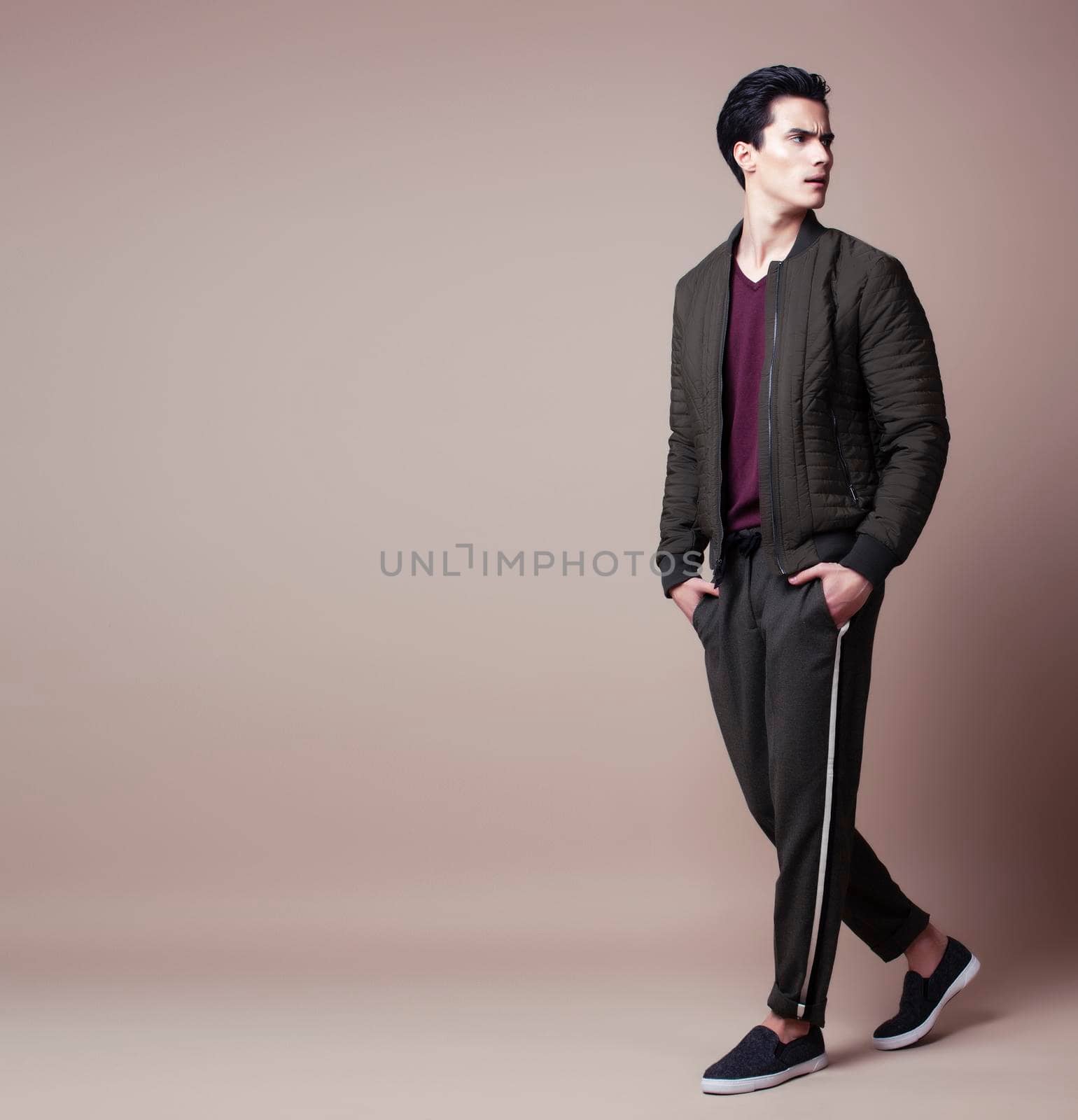 young pretty asian man posing in fashion style on light brown background, lifestyle people concept close up