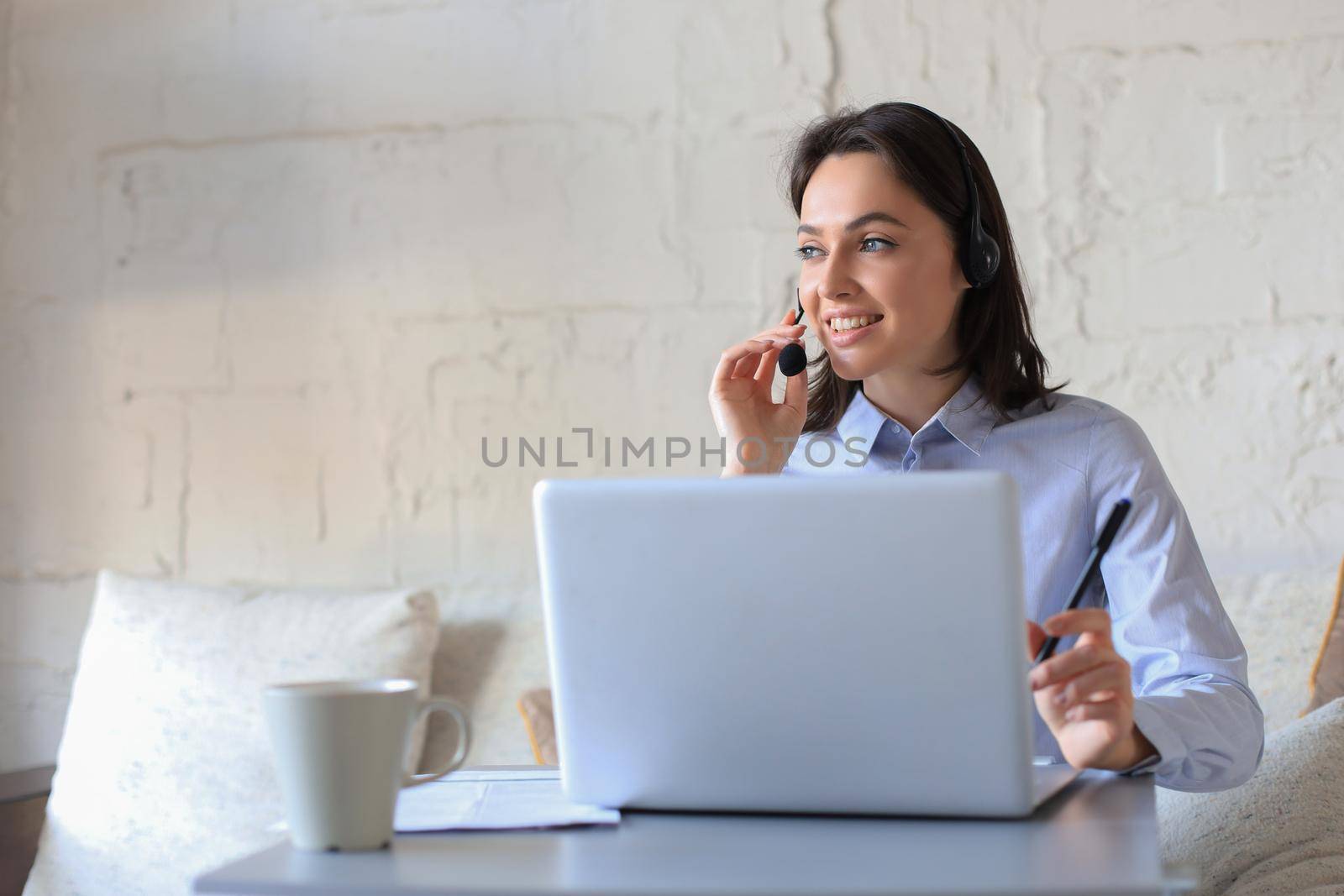 Freelance operator talking with headsets and consulting clients from home office