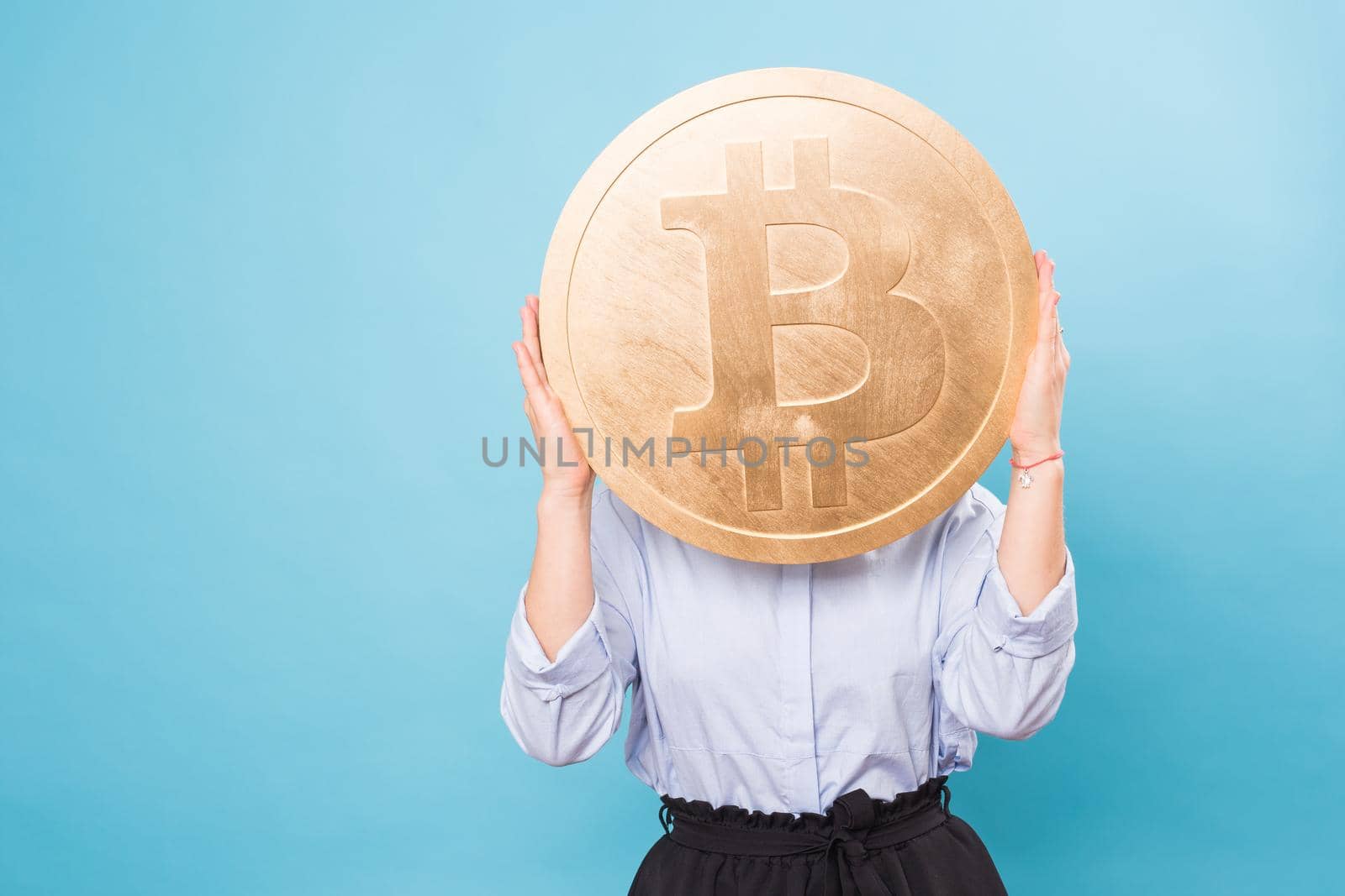 woman holding a big Golden Bitcoin. virtual money.