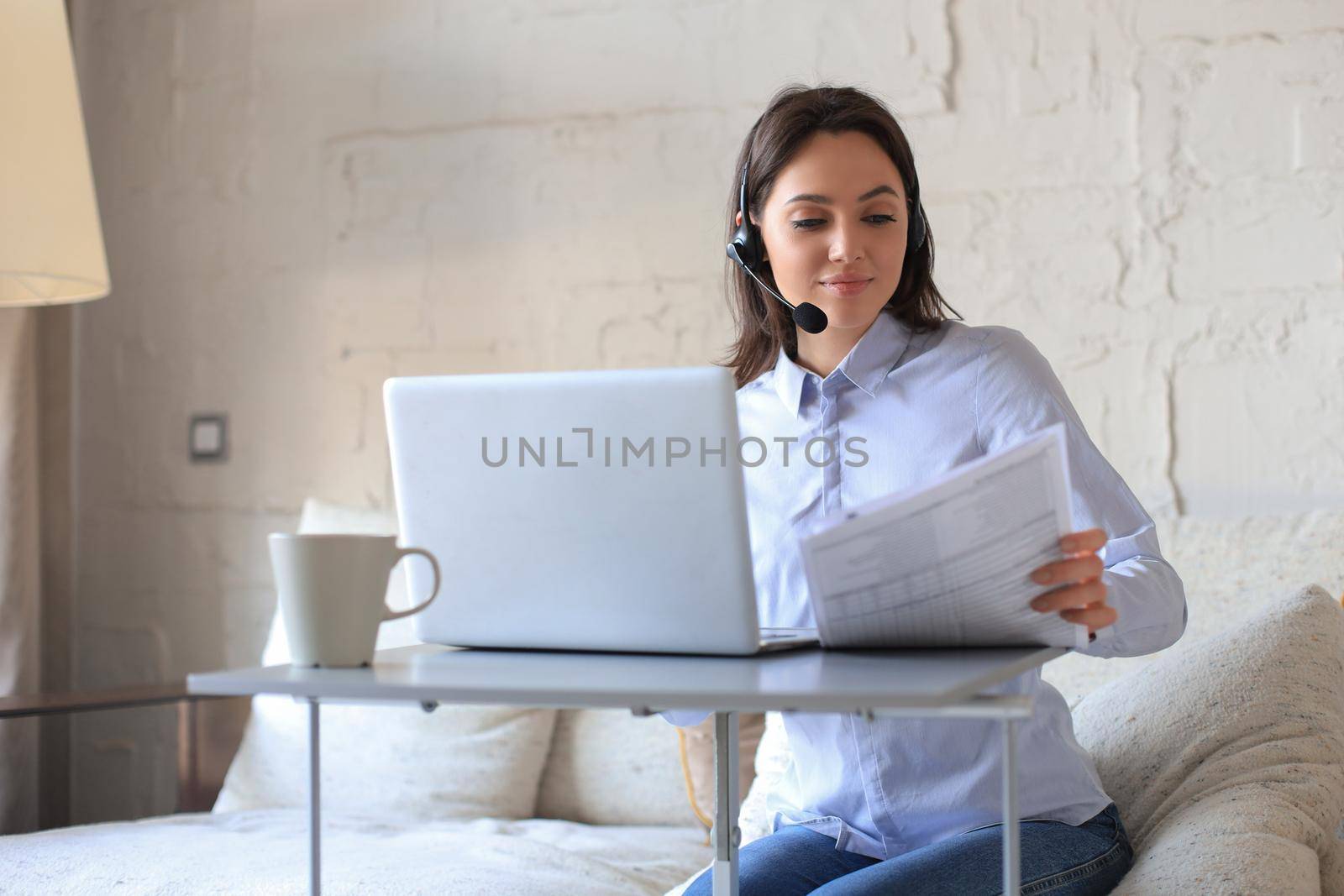 Freelance operator talking with headsets and consulting clients from home office