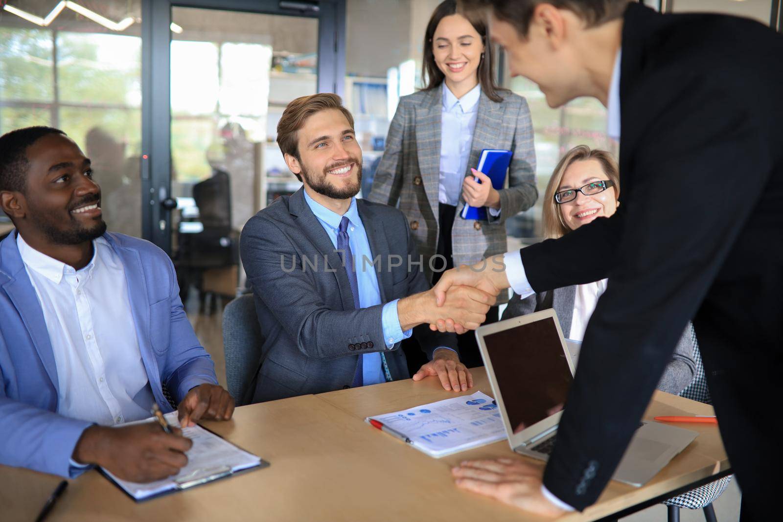 Business meeting associates shaking hands in office