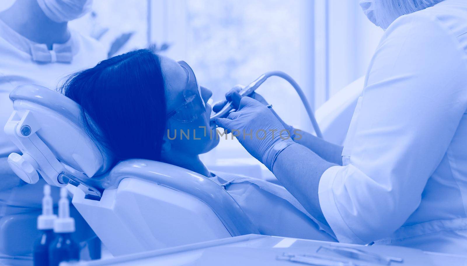 Young woman dentist at work in the office by lenets