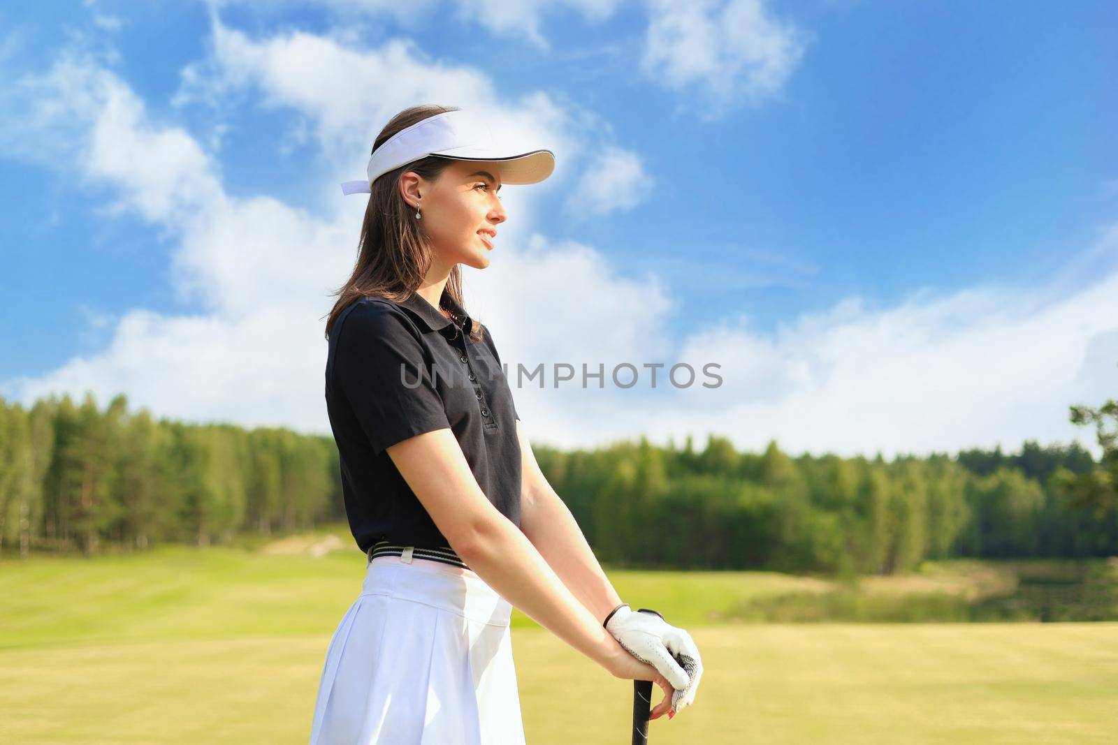 Woman golfer hits an fairway shot towards the club house
