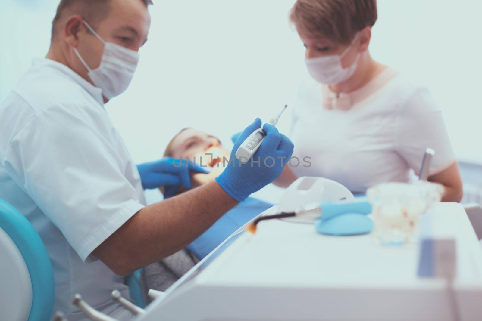 Detail of hand holding dental tools in dental clinic. Dentist Concept by lenets