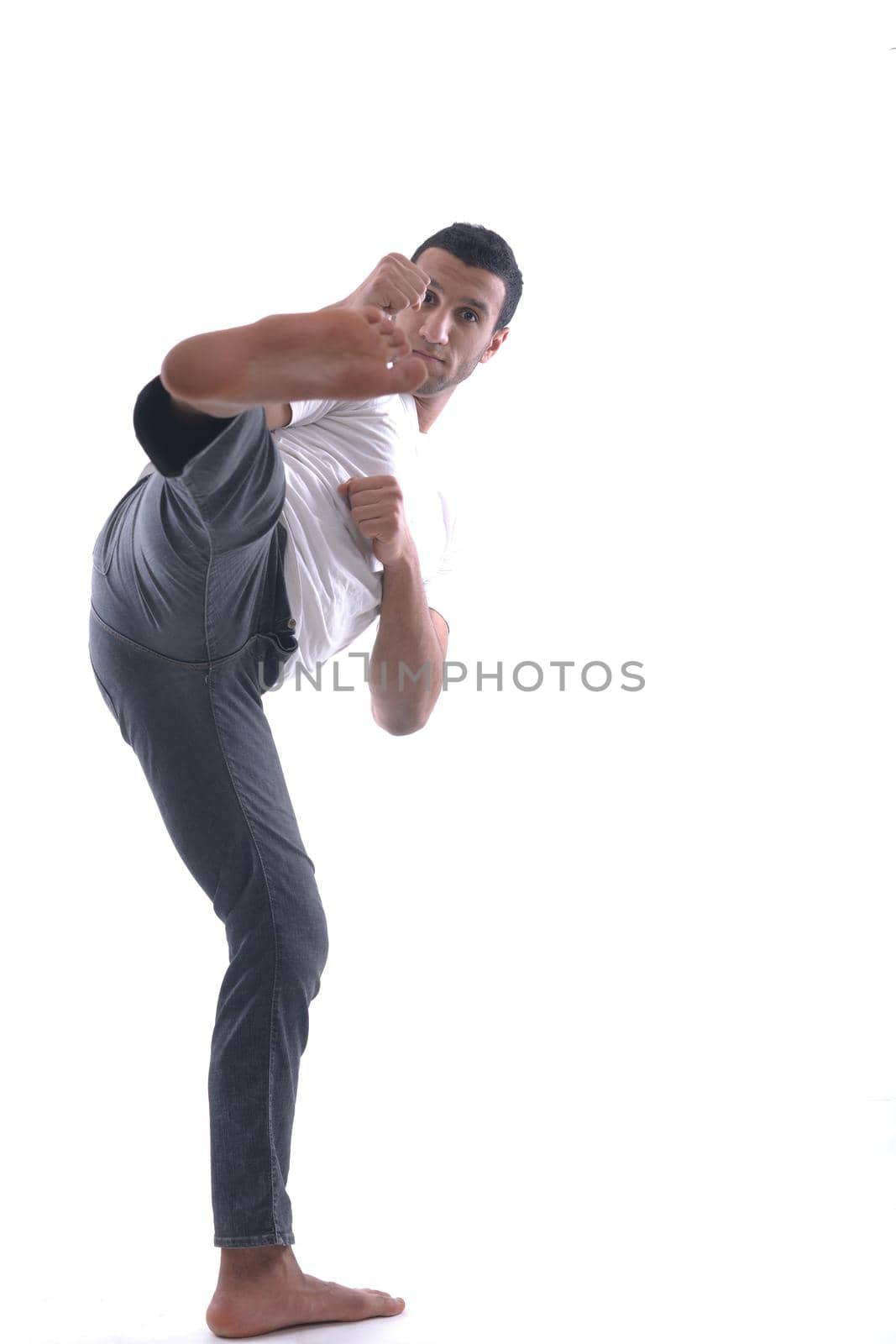 portrait of relaxed young man dressed in white shirt and jeans isolated over white background in studio