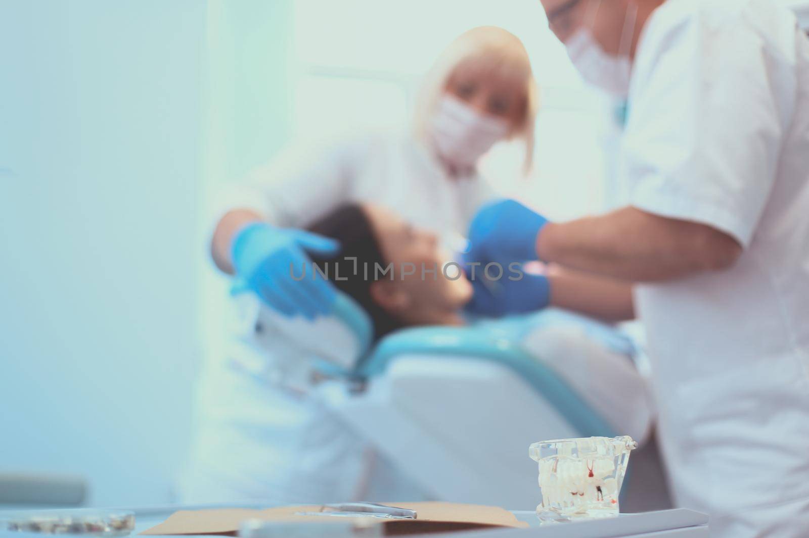 Portrait of a dentist who treats teeth of young woman patient by lenets
