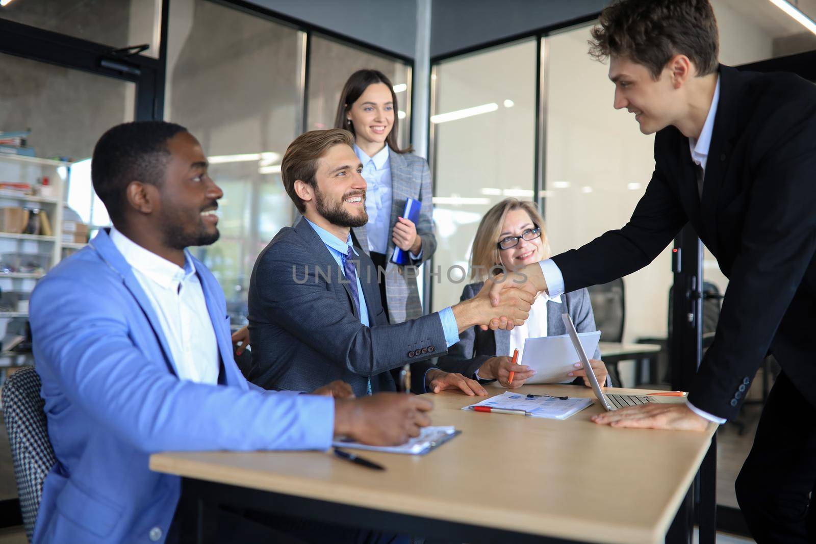 Handshake as successful negotiation ending, close-up. Unknown business people shaking hands after contract signing in modern office