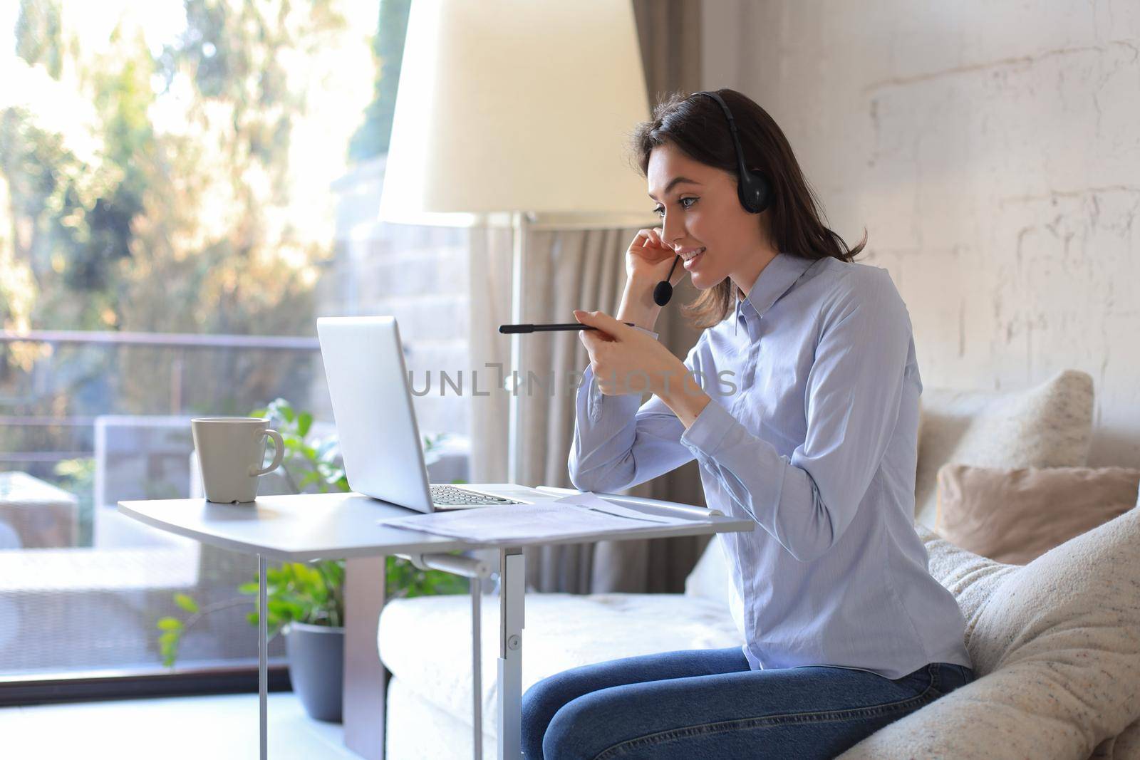 Freelance operator talking with headsets and consulting clients from home office