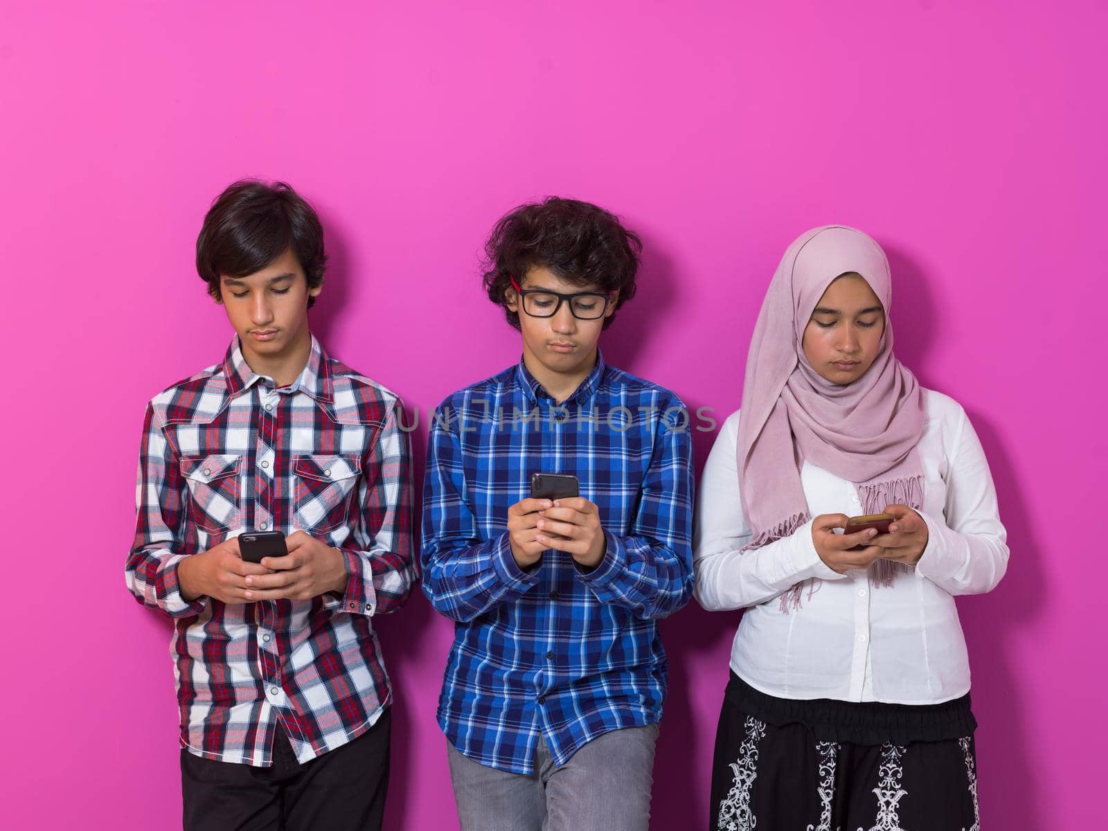 Arab teenagers group using smartphones for social media networking and sharing information for online education. High quality photo. Selective focus 
