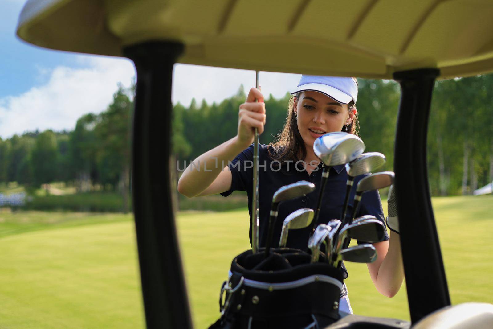 Professional woman golf player choosing the golf club from the bag