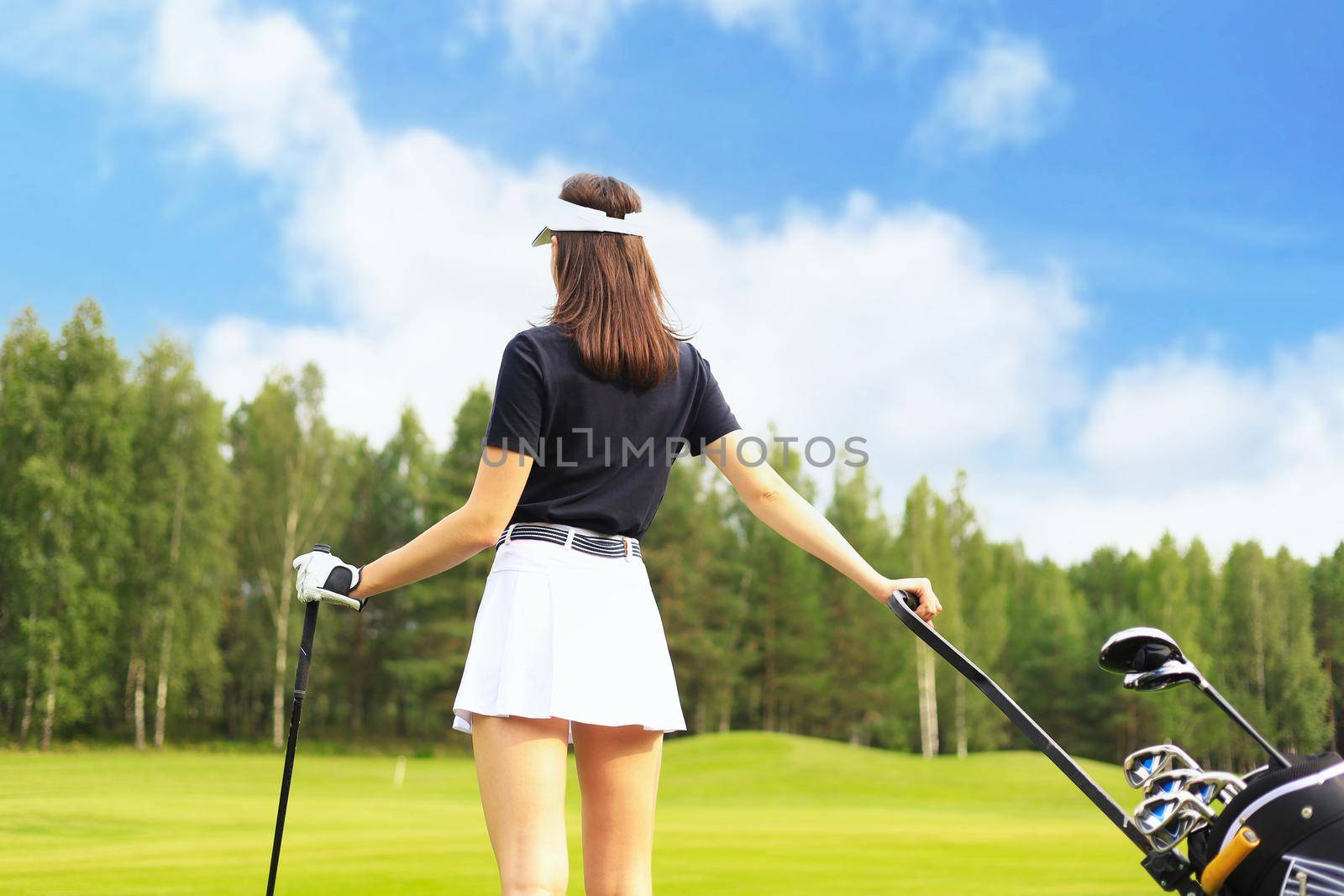 Young woman on golf course, back view