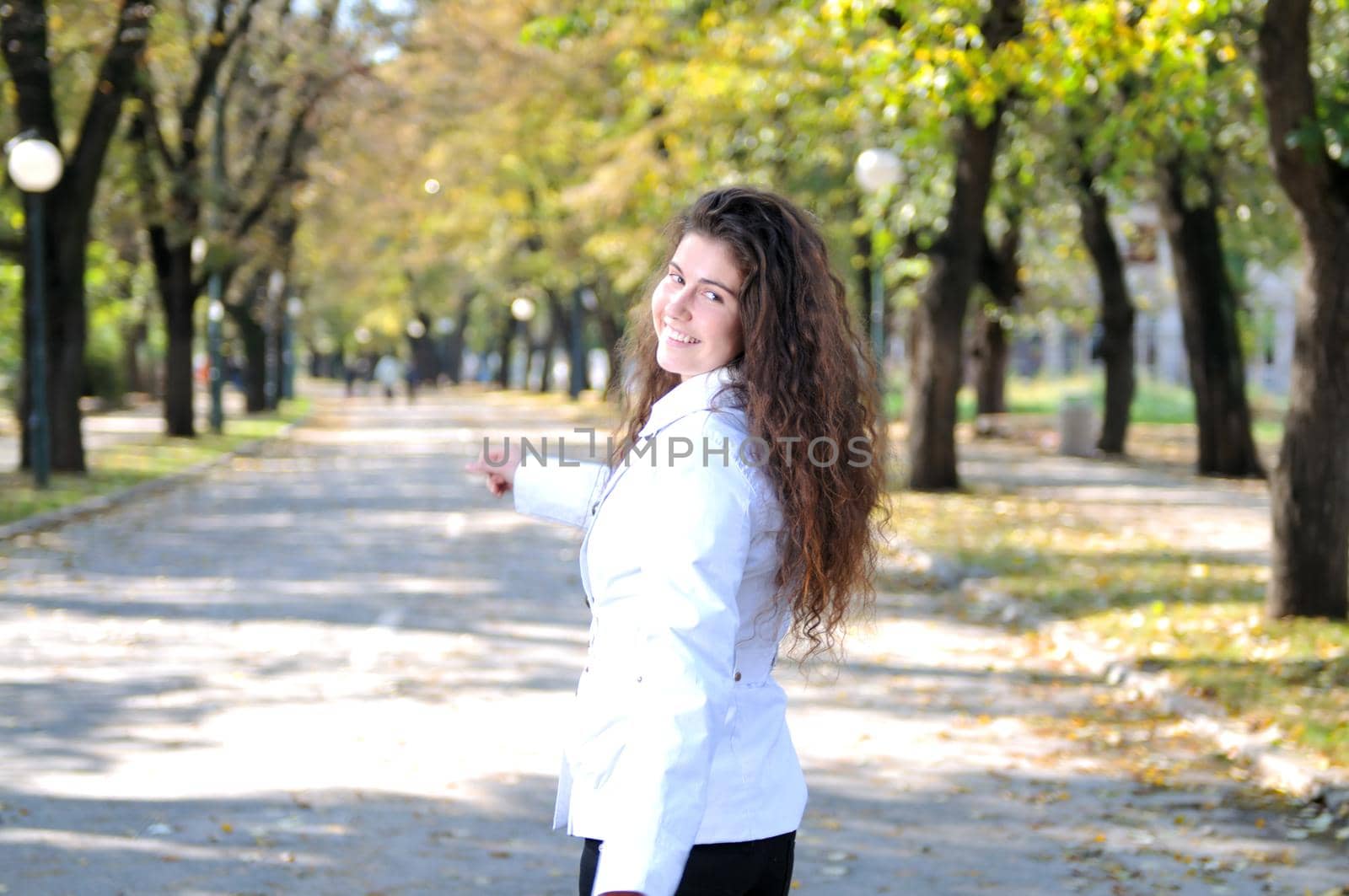 brunette Cute young woman smiling outdoors in nature by dotshock