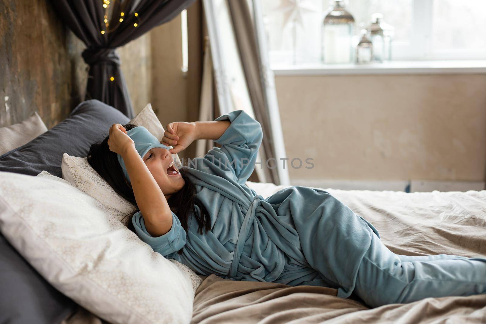 Adorable happy little kid girl after sleeping in bed