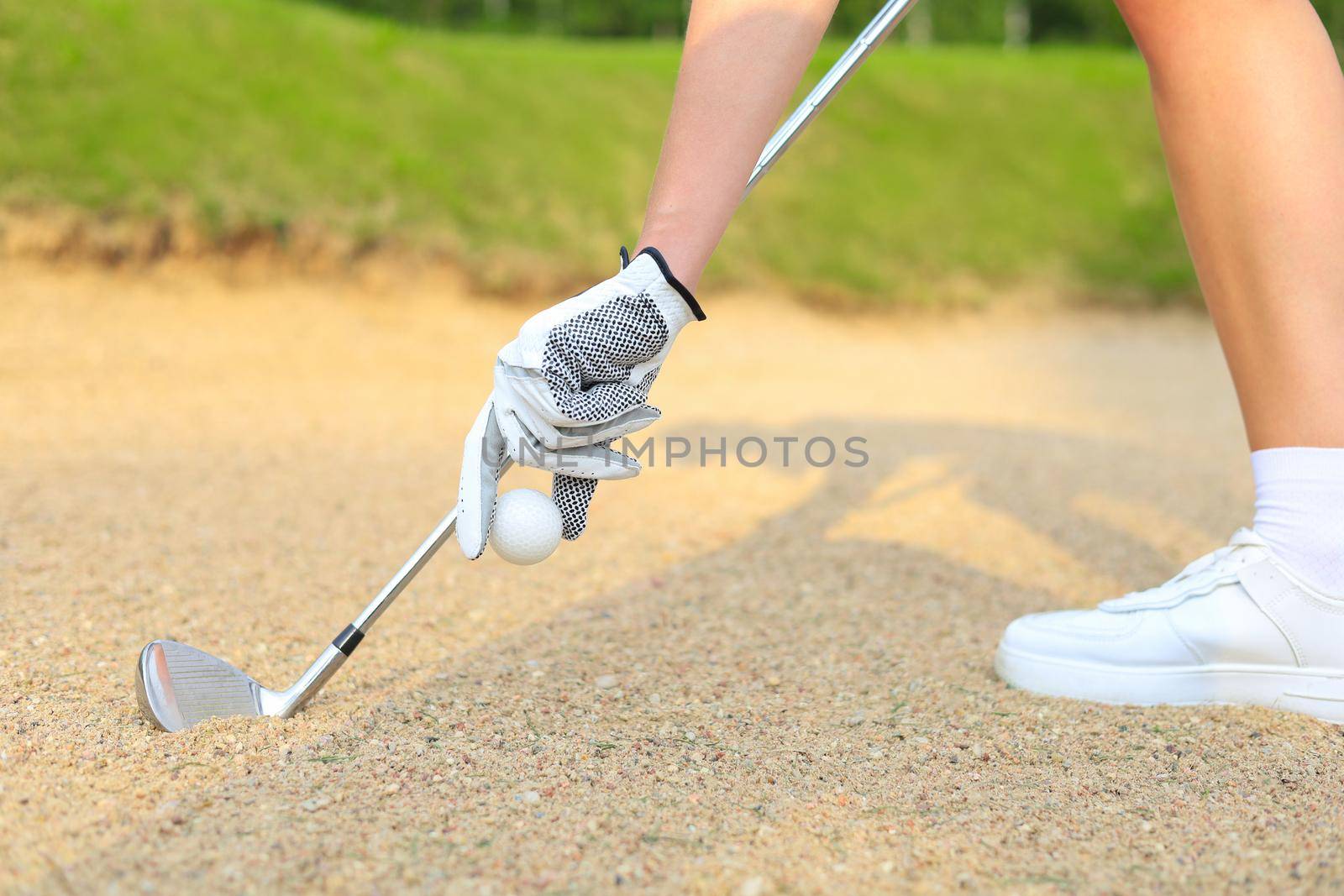 Hand putting golf ball on tee in golf course. by tsyhun