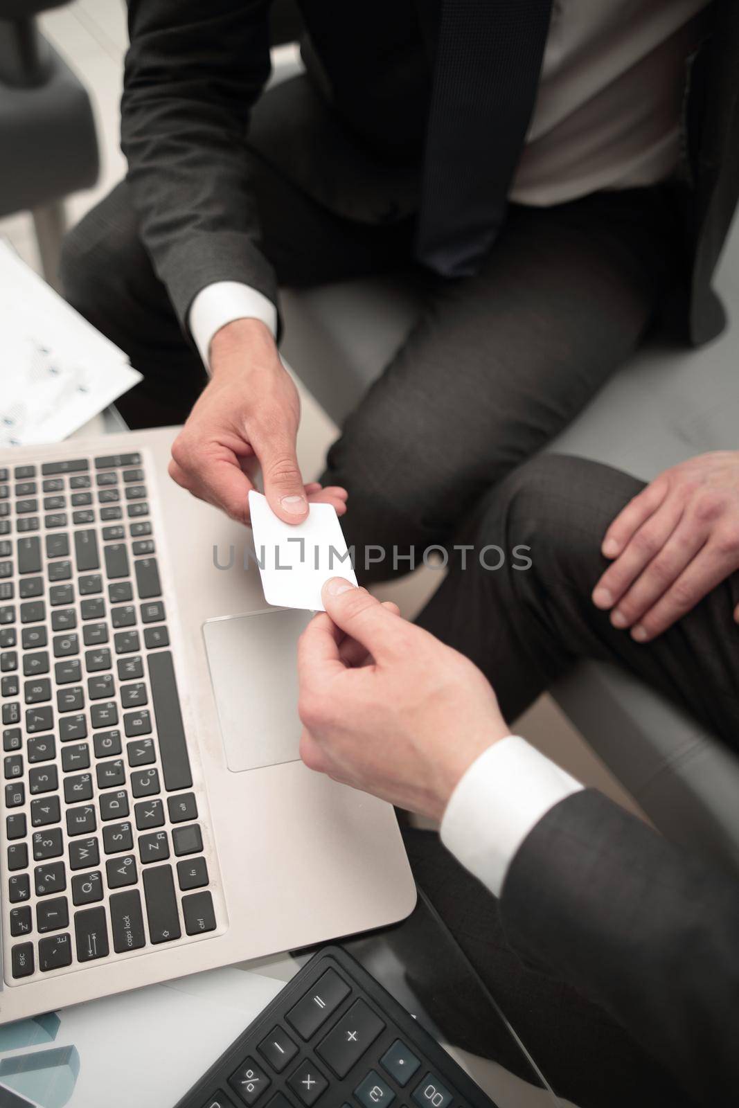 close up.business people exchange their business cards.concept of partnership