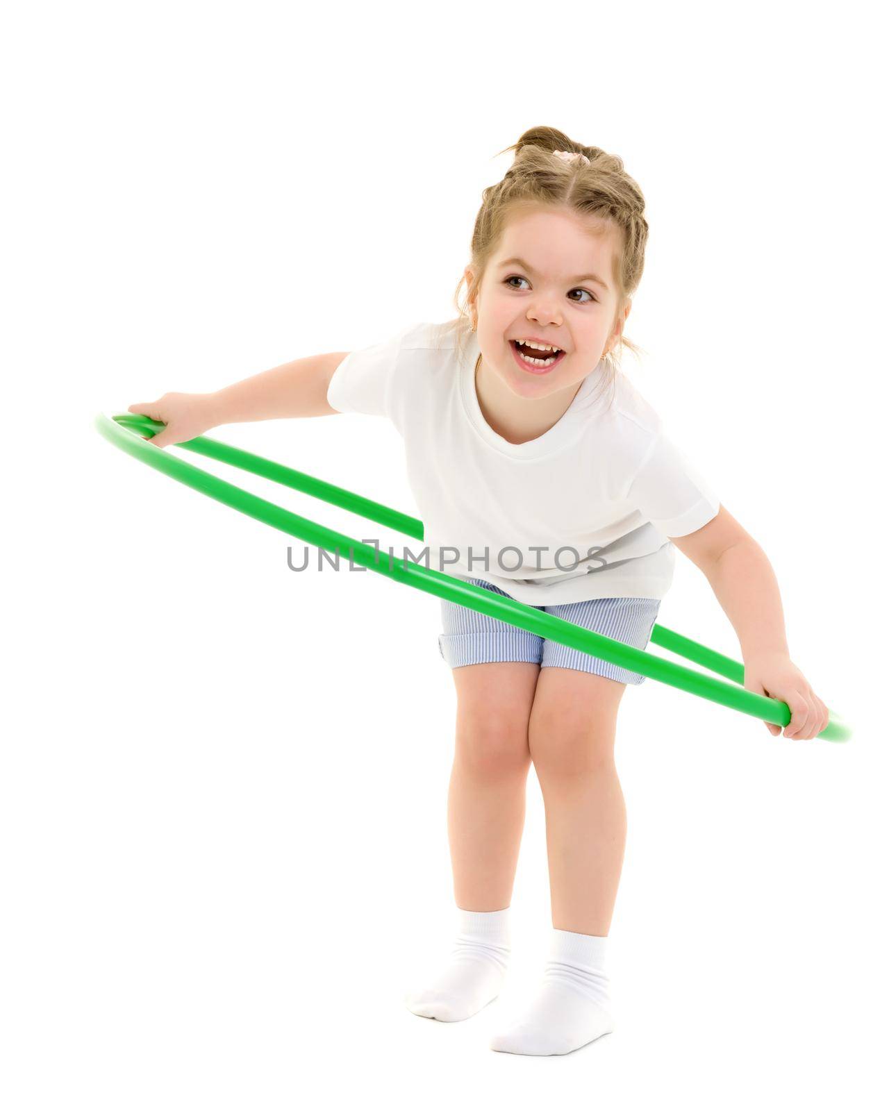 A little girl in a white T-shirt performs exercises with a hoop. by kolesnikov_studio