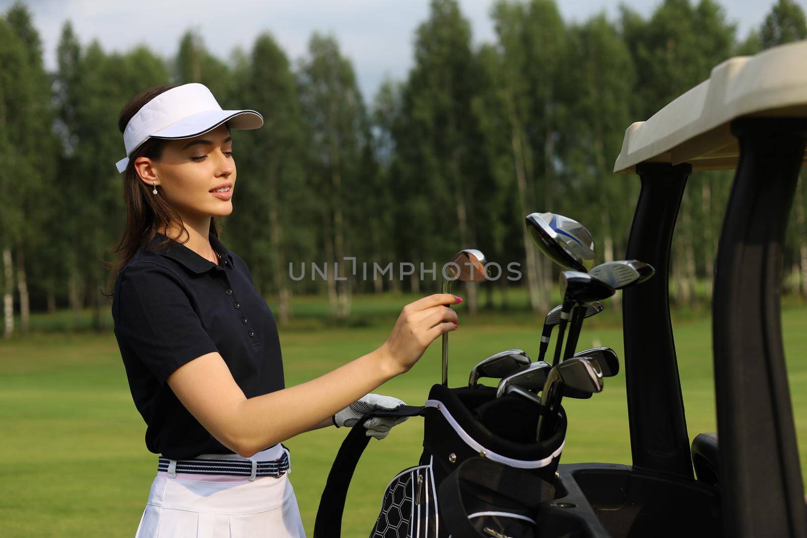 Professional woman golf player choosing the golf club from the bag
