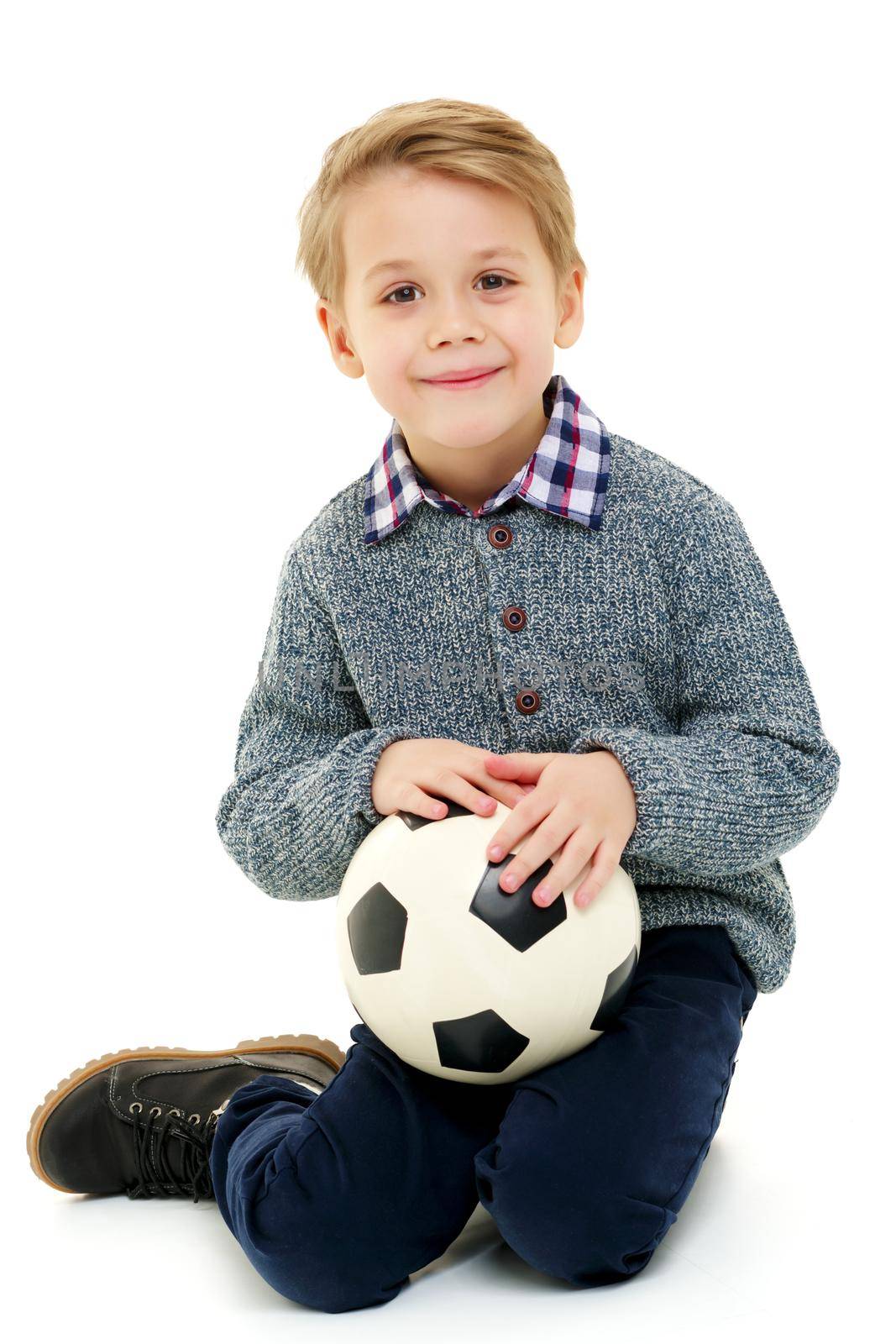 A sporty little boy is playing with a soccer ball. Concept of a healthy lifestyle, sport and fitness. Isolated on white background.