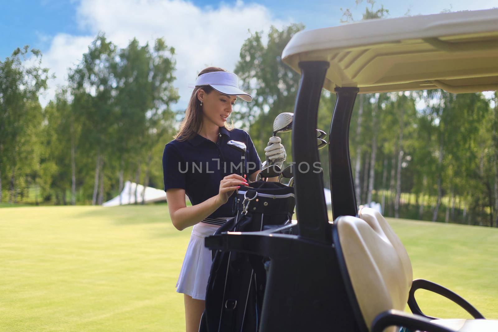 Professional woman golf player choosing the golf club from the bag