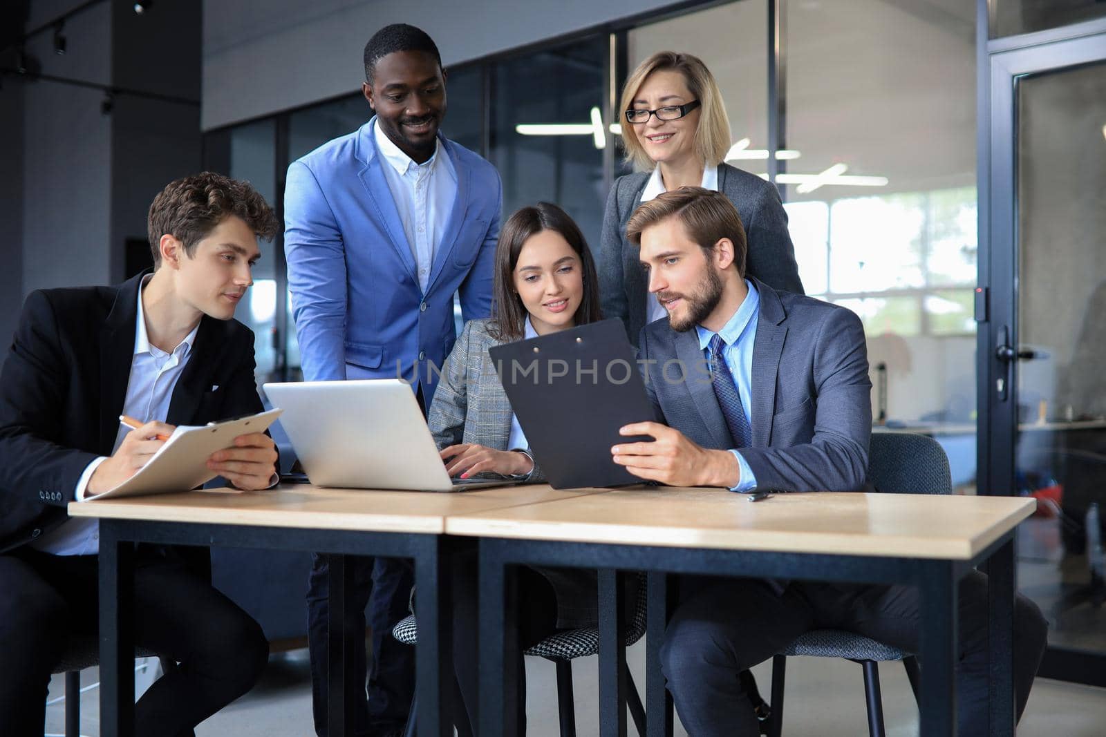 Group of happy young business people in a meeting at office. by tsyhun