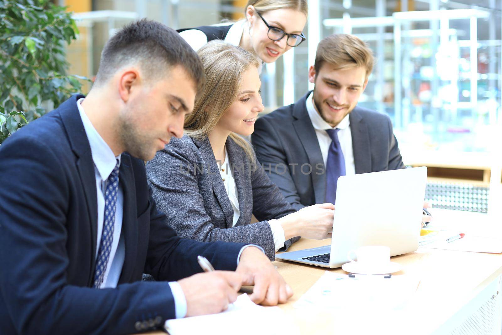 Startup business team on meeting in modern bright office interior and working on laptop