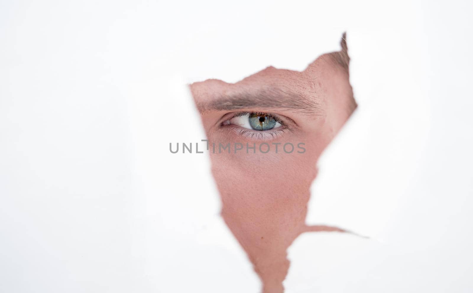 close up. businessman looking through a hole in the paper wall.photo with copy space