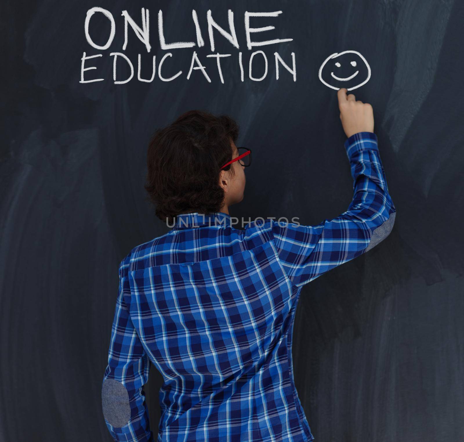 Smart  Teen Boy writing with chalk  online education  on  black board in school coronavirus stay at home concept