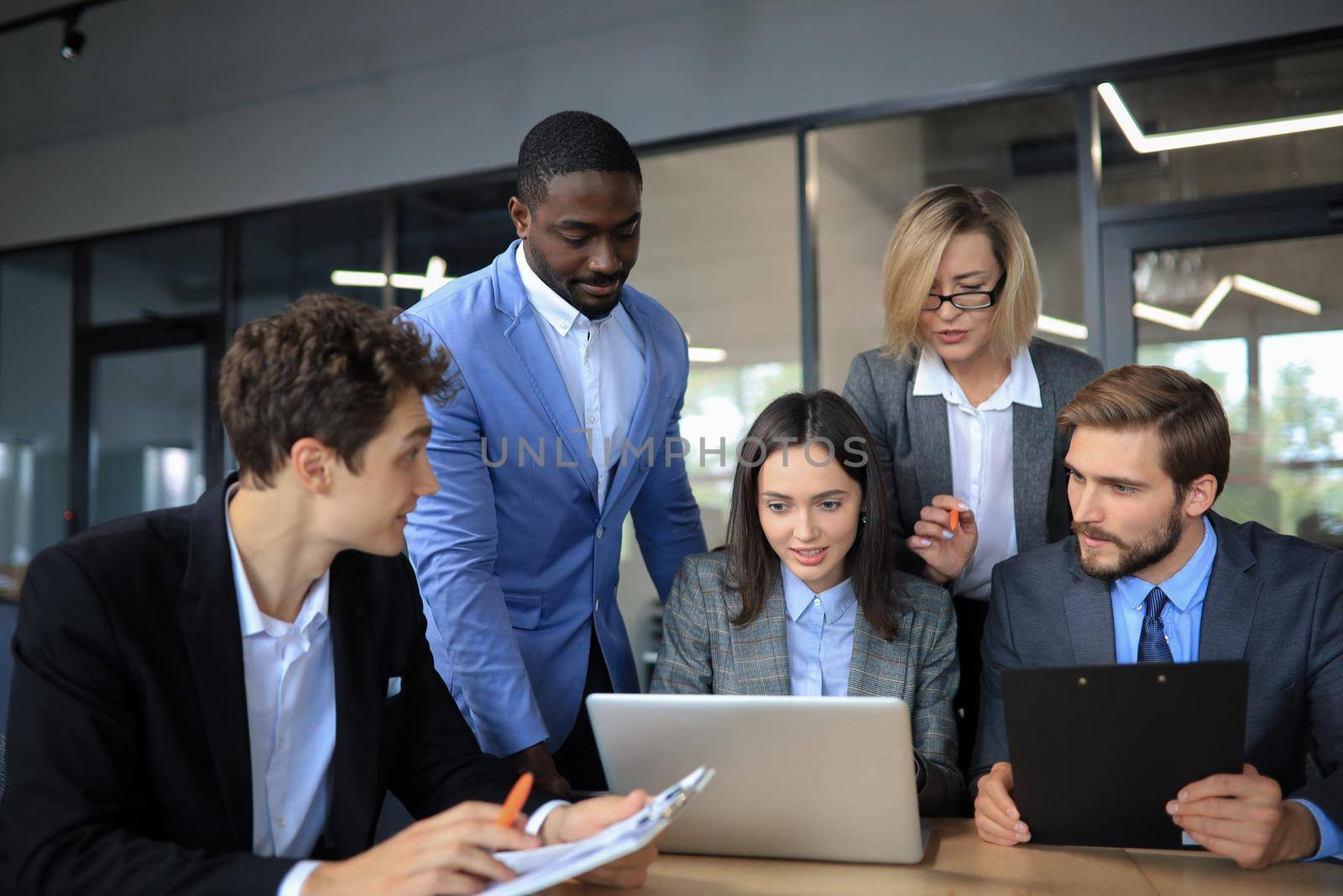 Startup business team on meeting in modern bright office interior and working on laptop