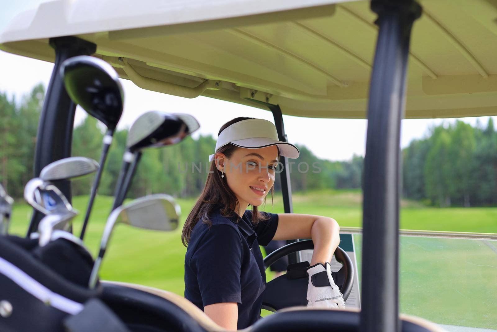 Beautiful cheerful woman driving golf cart