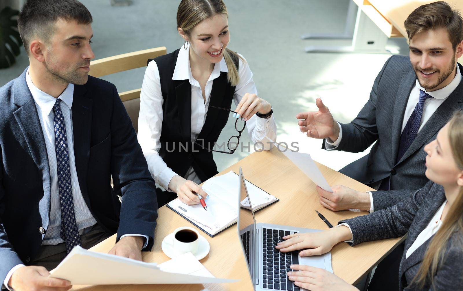 Image of business partners discussing documents and ideas at meeting. by tsyhun