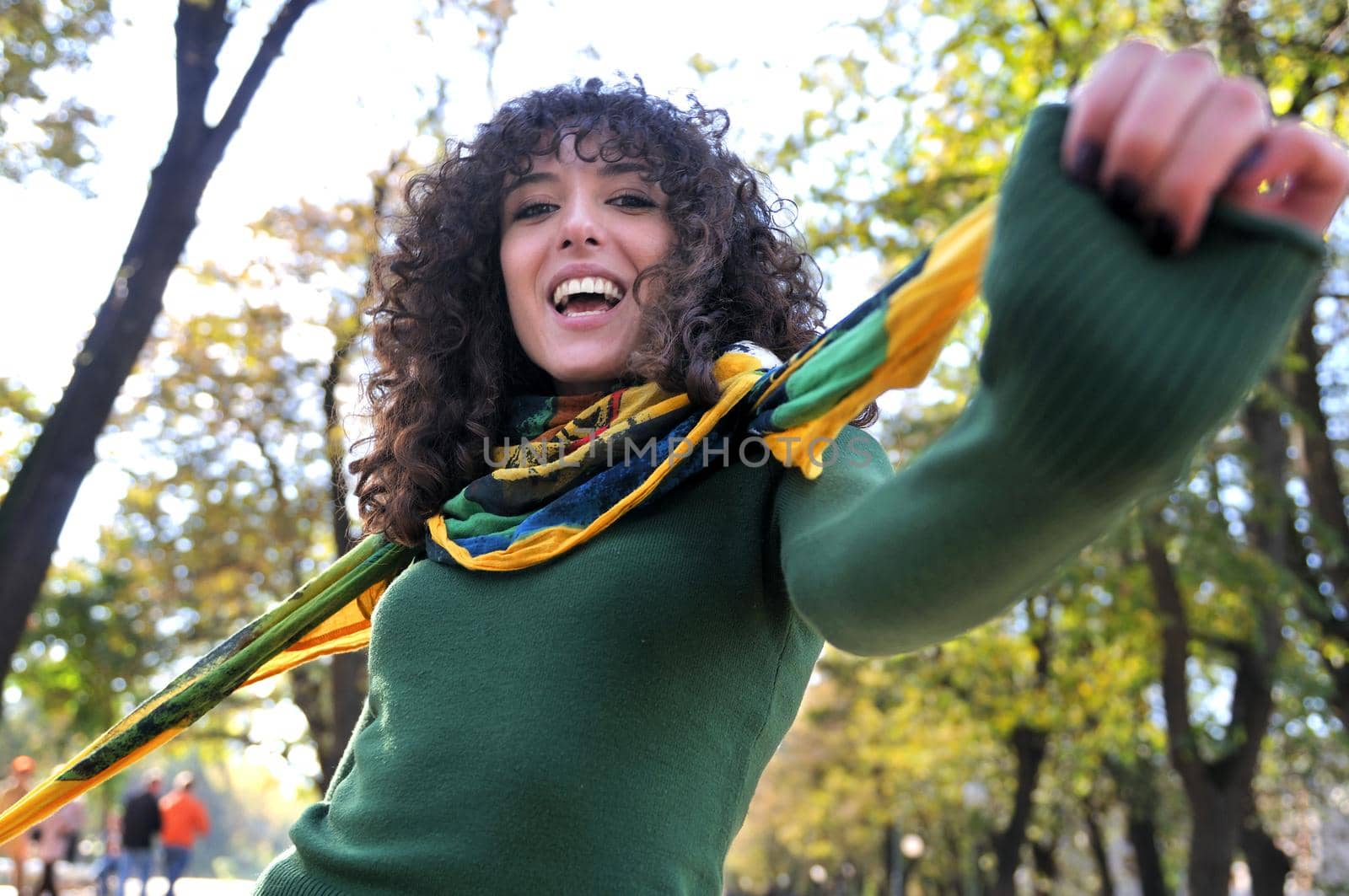 Young curly woman smiling outdoors in nature