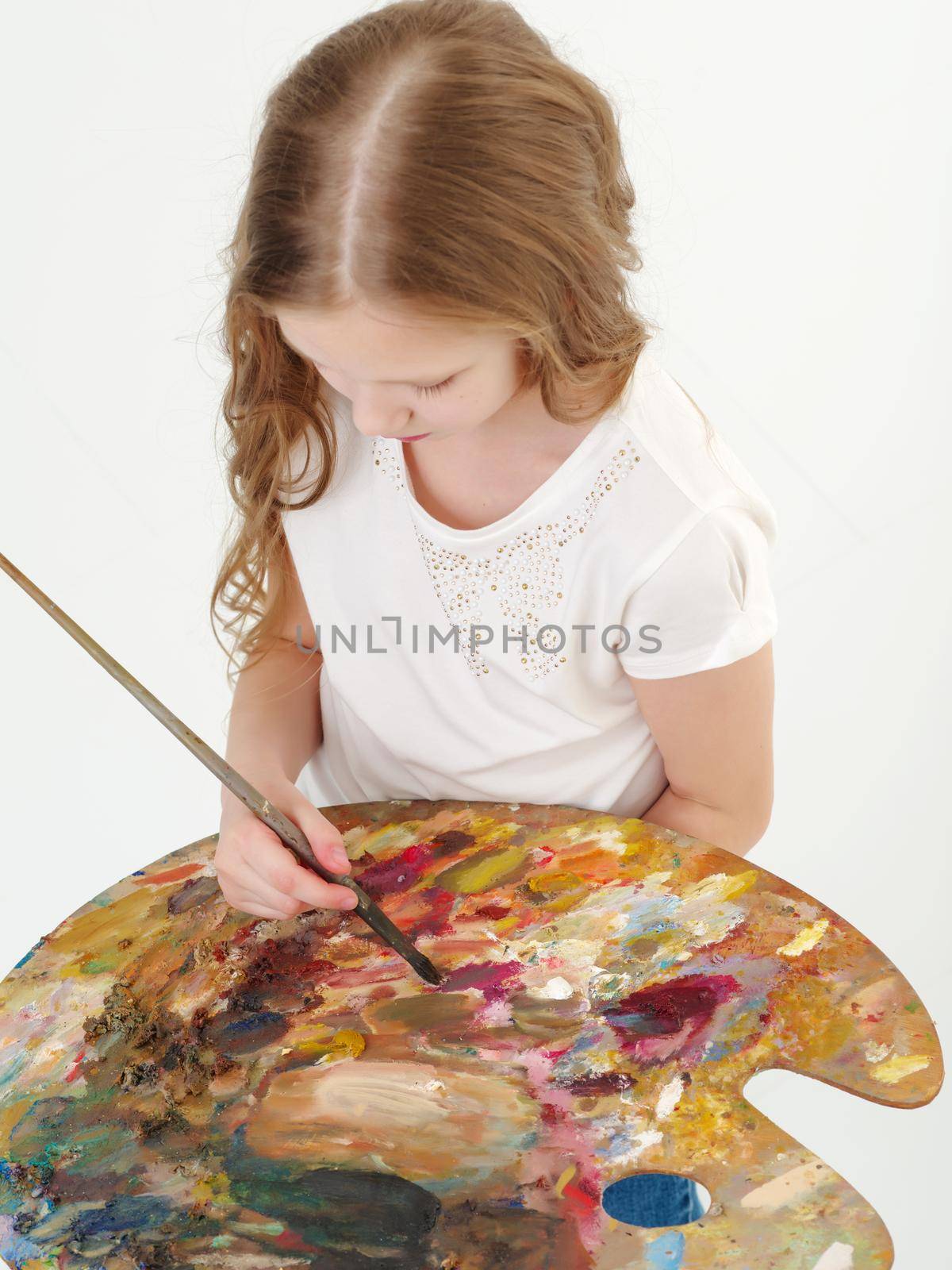 Little girl with palette and brush learning to draw. by kolesnikov_studio