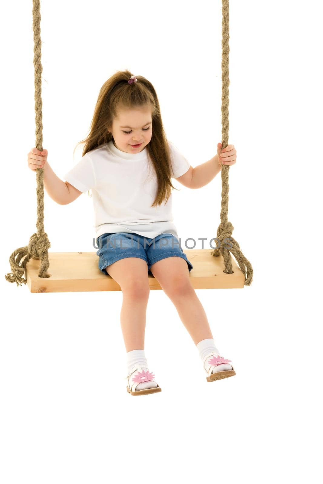 Beautiful little girl swinging on a swing. The concept of family happiness, summer holidays. Isolated on white background.